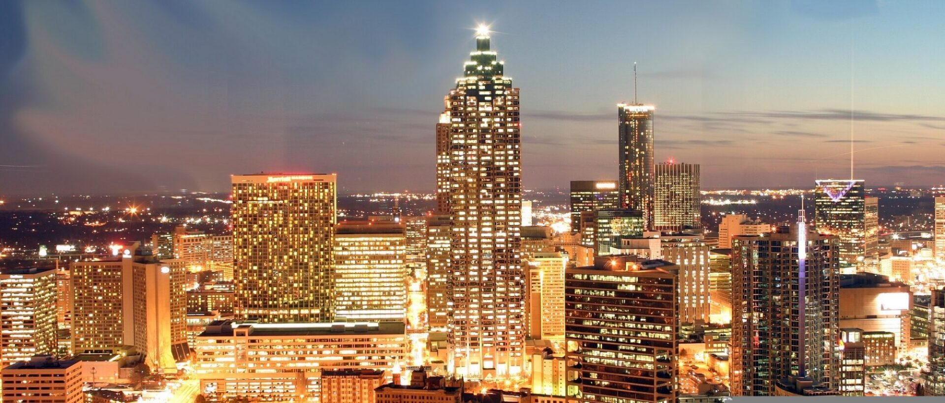 City skyline at dusk with illuminated buildings.