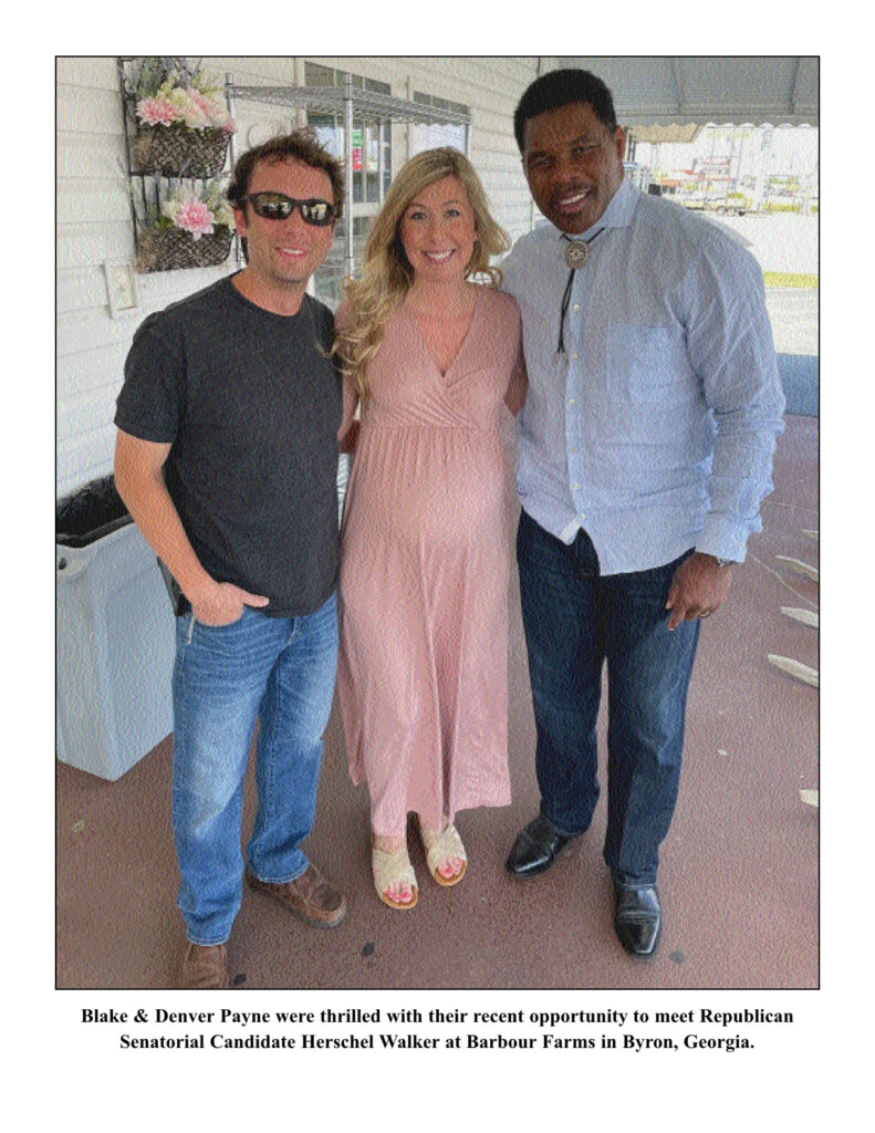 Three people smiling and posing together.