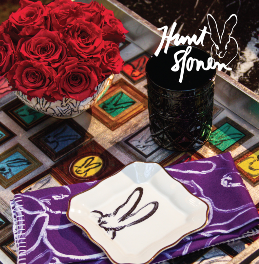 Red roses and rabbit-themed dinnerware on table.