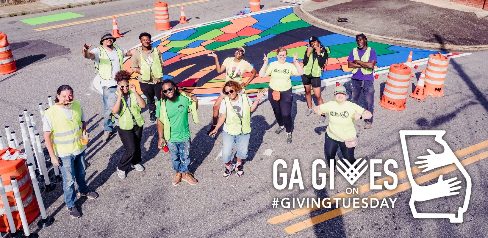 Group of volunteers painting colorful street mural.