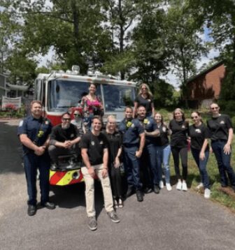 Group posing in front of fire truck.