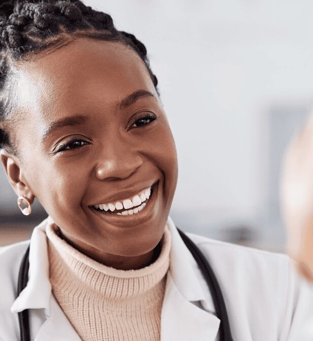 Smiling professional woman in white coat.