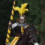 A medieval knight in armor with lance on horseback during a jousting event in Germany.