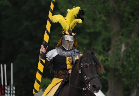 A medieval knight in armor with lance on horseback during a jousting event in Germany.
