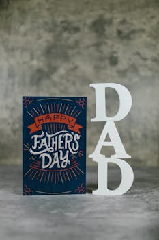 Close-up of a stylish Father's Day card with 'DAD' decorative letters on a textured background.